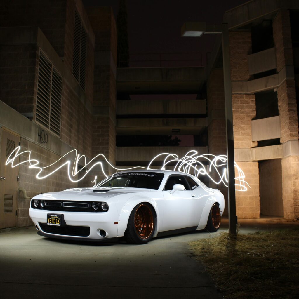 pexels-photo-733745-733745 White luxury sports car parked with dynamic light trails at night against a building backdrop.